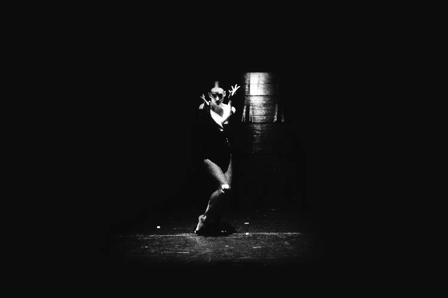Bailarina en escena junto a una columna de luz